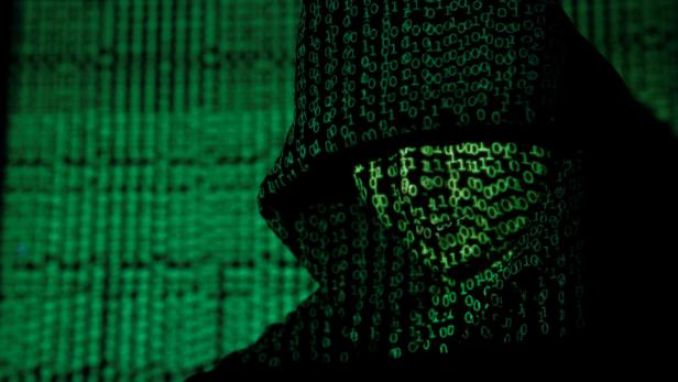 Projection of cyber code on hooded man is pictured in this illustration picture Die Kryptoforensiker: Neue Ermittler überführen Cyber-Täter