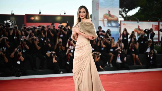 Angelina Jolie auf dem roten Teppich in einem beigen Kleid und einer Stola.