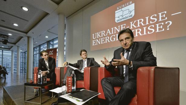 Drei Männer sitzen auf einer Bühne bei einer Podiumsdiskussion zum Thema Ukraine-Krise und Energiekrise.