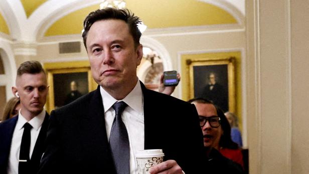 FILE PHOTO: Members of US Congress meet with Musk and Ramaswamy on Trump's government efficiency plan Elon Musk hält einen Kaffeebecher in der Hand