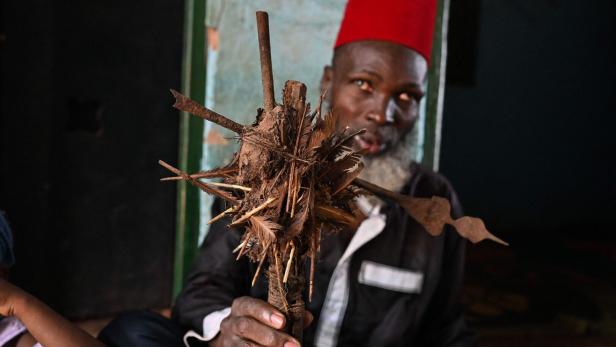 Mory Bamba, ein muslimischer Religionsführer, der gegen die Beschneidung von Mädchen kämpft, hält am 10. Juli 2024 in seinem Dorf in der Nähe von Touba einen Fetisch, der früher von Beschneiderinnen verwendet wurde.