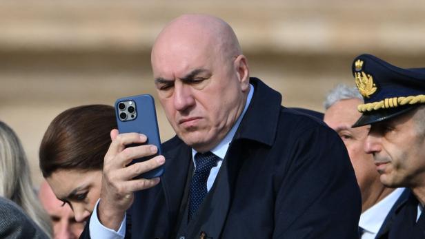 Ein Mann schaut auf sein blaues Handy.