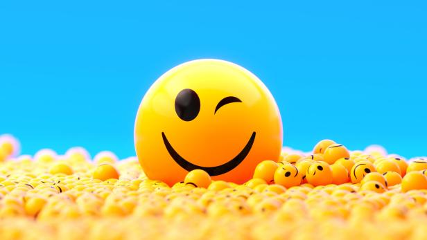 Yellow Spheres Textured With Happy Face Emoji On Blue Background
