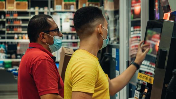KI entlarvt Ladendiebstahl in Supermarkt und Drogerie in Sekunden SB-Kasse: Zwei Männer stehen beim Self-Checkout