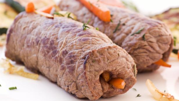 Zwei Rindsrouladen mit Karottenfüllung auf einem Teller.