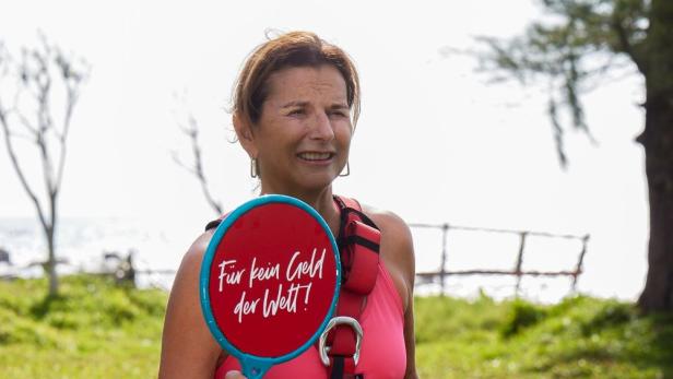 Claudia Obert posiert mit einem roten Schild, auf dem "Für kein Geld der Welt" steht