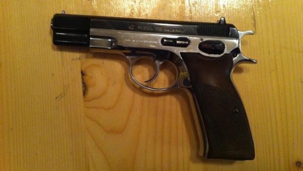 Eine Pistole des Modells CZ 75 liegt auf einem Holztisch.