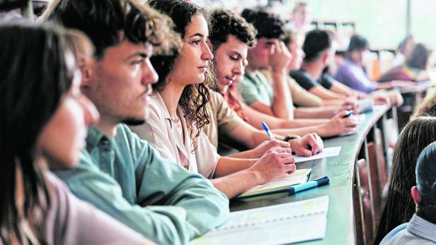 Young female student and her friends having a class in lecture hall.