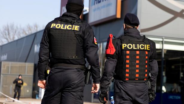 Zwei Polizisten stehen vor einem Gebäude mit der Aufschrift „Action“.