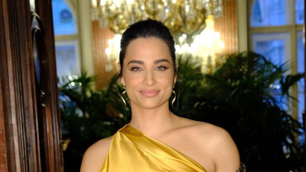 Amira Aly. Sie trägt ein goldenes Abendkleid.
