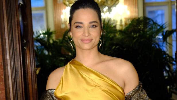 Amira Aly. Sie trägt ein goldenes Abendkleid.