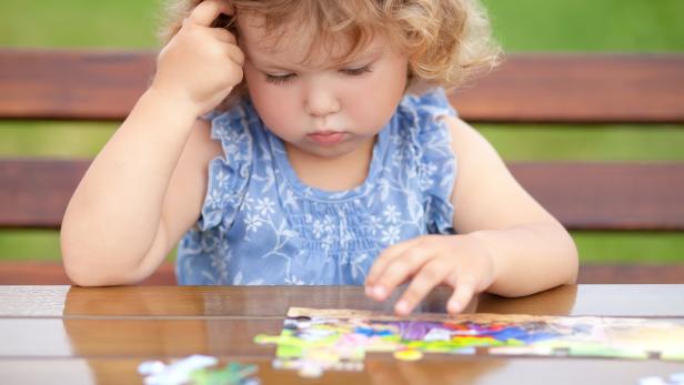 Kind spielt ein Puzzle.