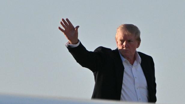 Ein Mann im Anzug hinter einer Tragfläche. Er trägt dunkles Sakko, helles Hemd und orange Haare.