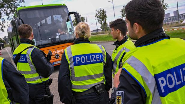 Polizisten kontrollieren einen Bus