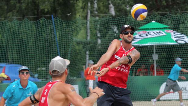 epa03776442 Clemens Doppler (R) and Alexander Horst (L) from Austria during the match with Juan Virgen/ Lombardo Ontiveros (Mexico) at the Beach Volleyball World Championships 2013 in Stare Jablonki, Poland, 05 July 2013. EPA/TOMASZ WASZCZUK POLAND OUT