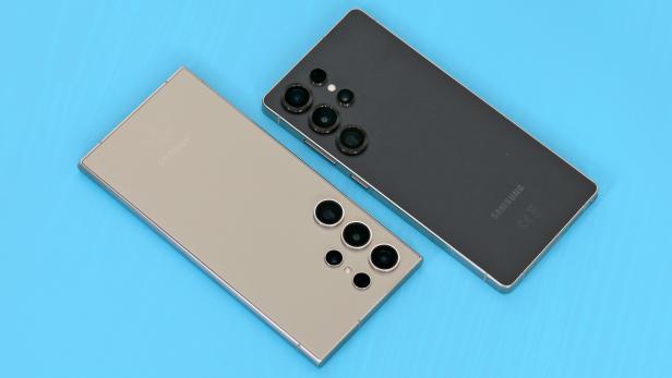 Zwei Samsung Galaxy Smartphones, ein S24U und ein S25U, liegen auf einem blauen Hintergrund.