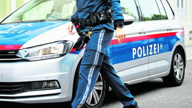 Polizist vor Streifenwagen