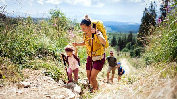 Family with small children hiking outdoors in summer nature, walking in High Tatras. Familie wandert in der Natur