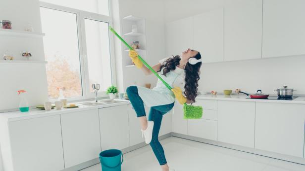 Frau putzt motiviert die Wohnung.