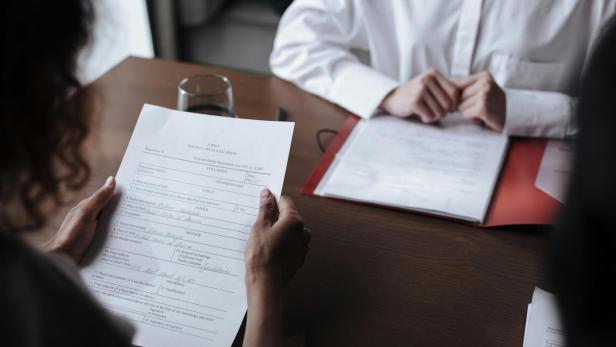 Frau und Mann sitzen für ein Bewerbungsgespräch gemeinsam am Tisch