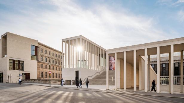 Die Sonne scheint durch ein Gebäude auf die Straße.