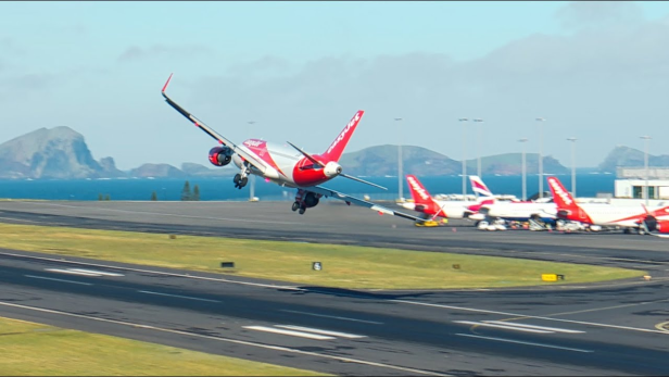 Ein Easyjet-Flugzeug landet auf einer Landebahn mit anderen Flugzeugen im Hintergrund.