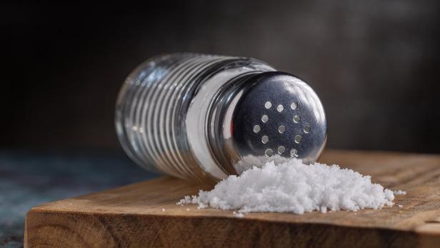 Ein umgefallener Salzstreuer liegt auf einem Tisch.