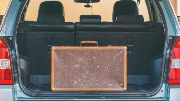 Old shabby leather suitcase in the trunk of a car Wer schluckt am meisten: Kofferraumgröße von 42 Autos im Test