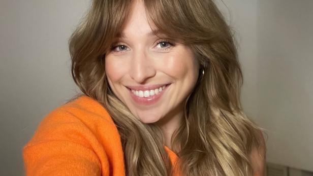 Bianca und Julian Caßen nach Trennung: Millionen-Villa zum Verkauf Bianca Heinicke: 32-jährige Frau mit dunkelblonden langen Haaren und orangefarbenem Pulli lächelt