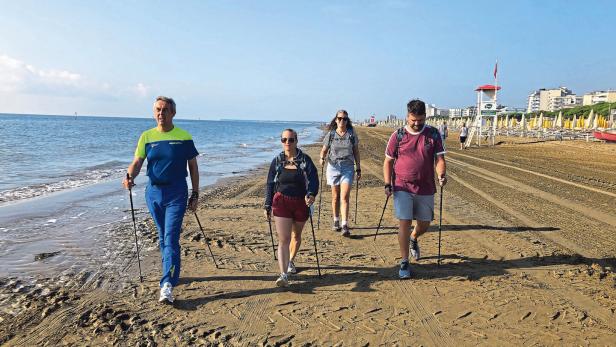 46-214114093 Eine Gruppe Menschen beim Nordic Walking am Strand von Lignano
