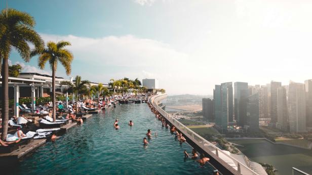 Nach dem verheerenden Erdbeben in Südostasien ging ein Video viral, in dem ein Pärchen in einem Hochhauspool zu sehen ist. Infinity Pool mit mehreren Menschen. An der Seite sieht man Palmen und Hochhäuser