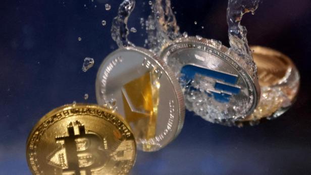 FILE PHOTO: Illustration shows representations of cryptocurrencies plunging into water