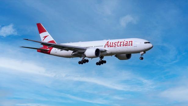 Boeing 777-200ER der Austrian Airlines, in der Luft, mit klarer Sicht auf die charakteristische Lackierung.