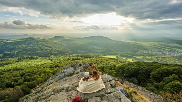 Zwei Wanderinnen, die den Sonnenuntergang am Berg Milseburg in Hofbieber betrachten