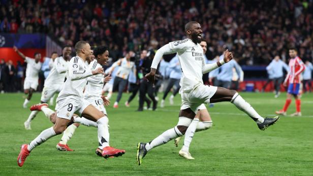 Fußballspieler von Real Madrid jubeln auf dem Spielfeld vor einer Zuschauermenge.