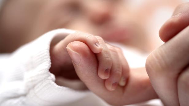 Diabetes in der Schwangerschaft begünstigt Entwicklungsstörungen Babyhand in elterlicher Hand