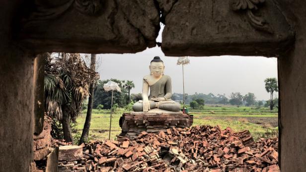 Eine Buddha-Statue ist von Trümmern umgeben in Inn Wa, am Stadtrand von Mandalay.