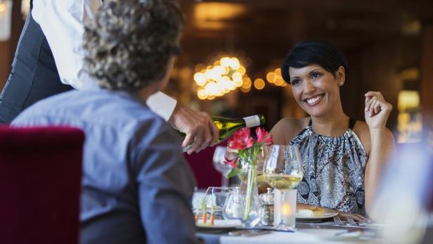 Paar genießt alkoholfreien Wein zum Essen (Symbolfoto).