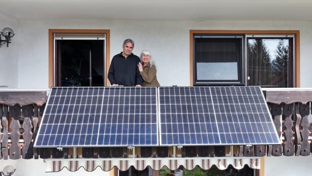 Ein Ehepaar auf einem typisch österreichisch aussehenden Balkon mit Balkonkraftwerk