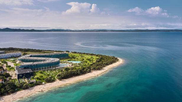 Eine Reise nach Kroatien ist vor allem im Frühling besonders schön. Eine Hotelanlage am Meer mit türkisblauem Wasser.