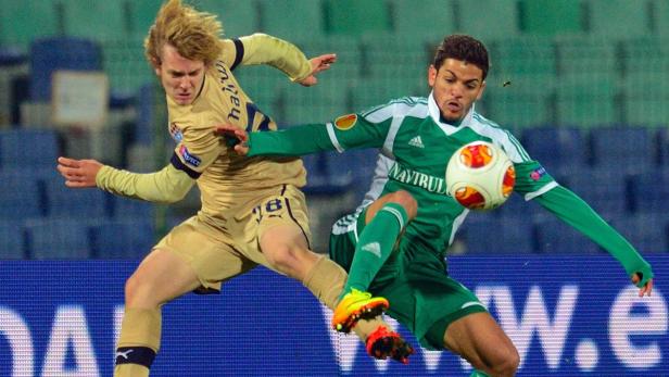 Zwei Fußballspieler kämpfen um den Ball während eines Spiels.