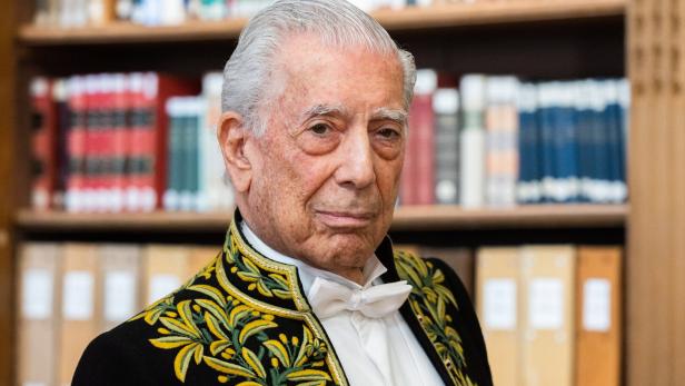 Vargas Llosa vor einem Bücherregal