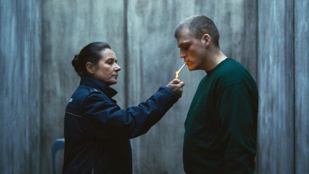 Eine Frau in Uniform zündet einem Mann eine Zigarette an.