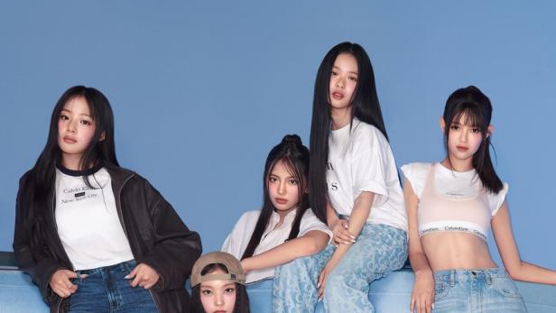 Mitglieder der K-Pop-Band New Jeans sind im Denim Look zu sehen.