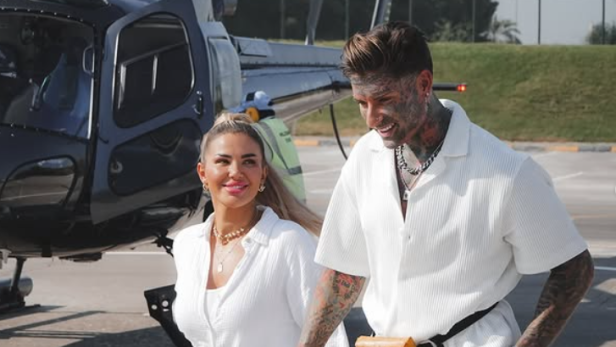 Kim Virginia und Nikola Glumac gehen Hand in Hand vor einem Helikopter