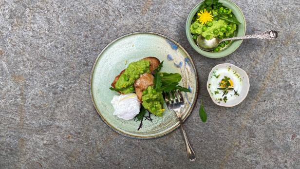 Teller mit Crostini, Erbsen-Löwenzahn-Creme und Kräuter-Ei.