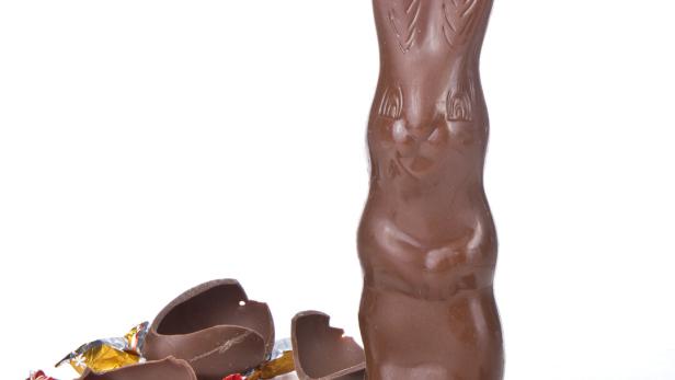 Ein Schokoladenhase steht neben den Überresten eines zerbrochenen Schokoladeneis.