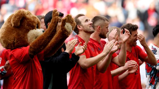 Die Bayern-Spieler und das Maskottchen applaudieren den Fans.