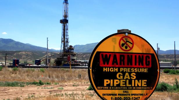 FILE PHOTO: A drilling rig operates as a sign warns of underground natural gas pipelines outside Rifle EU-Energiekommissar fordert mehr Gas-Importe aus den USA