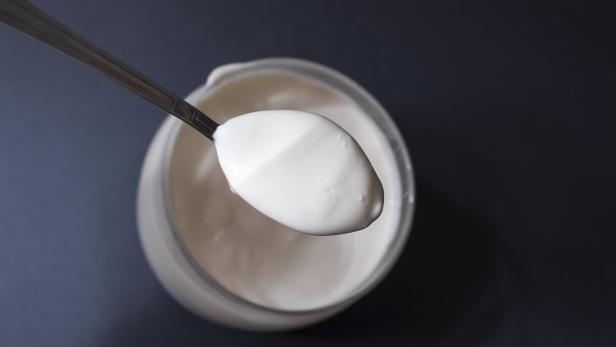 cream spoon Ein Löffel in einem Joghurtbecher.